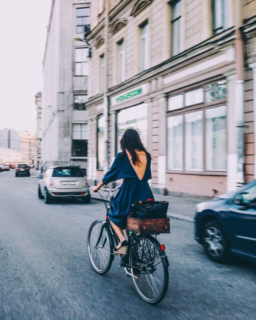 Kvinna cyklar genom stan en solig dag.