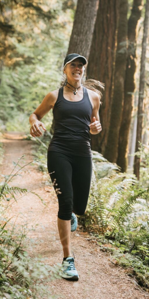 En person joggar på en gångväg i grön miljö.